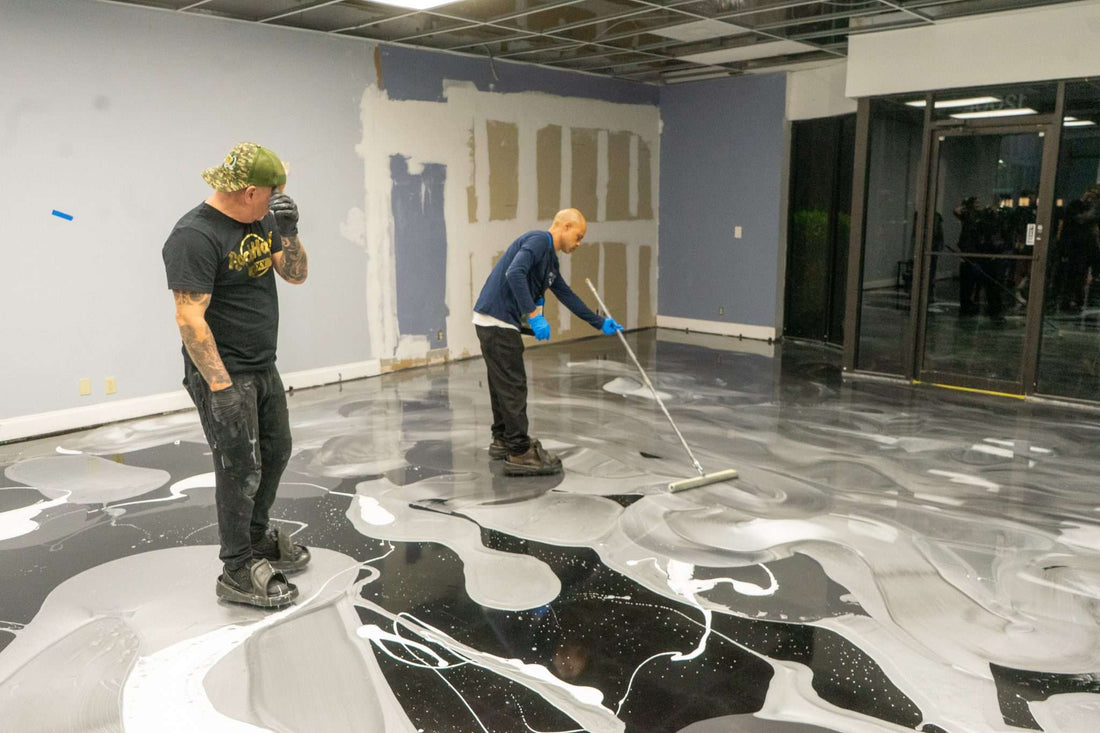 Two epoxy resin flooring contractors installing quick curing epoxy resin onto a commercial floor.