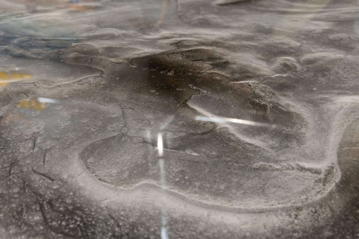 Epoxy resin with a glossy, gray metallic design installed on a concrete floor.