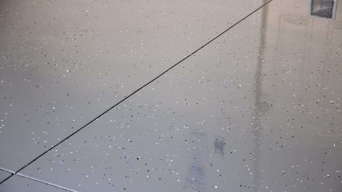 A vinyl flake epoxy resin floor installed in a garage carport.