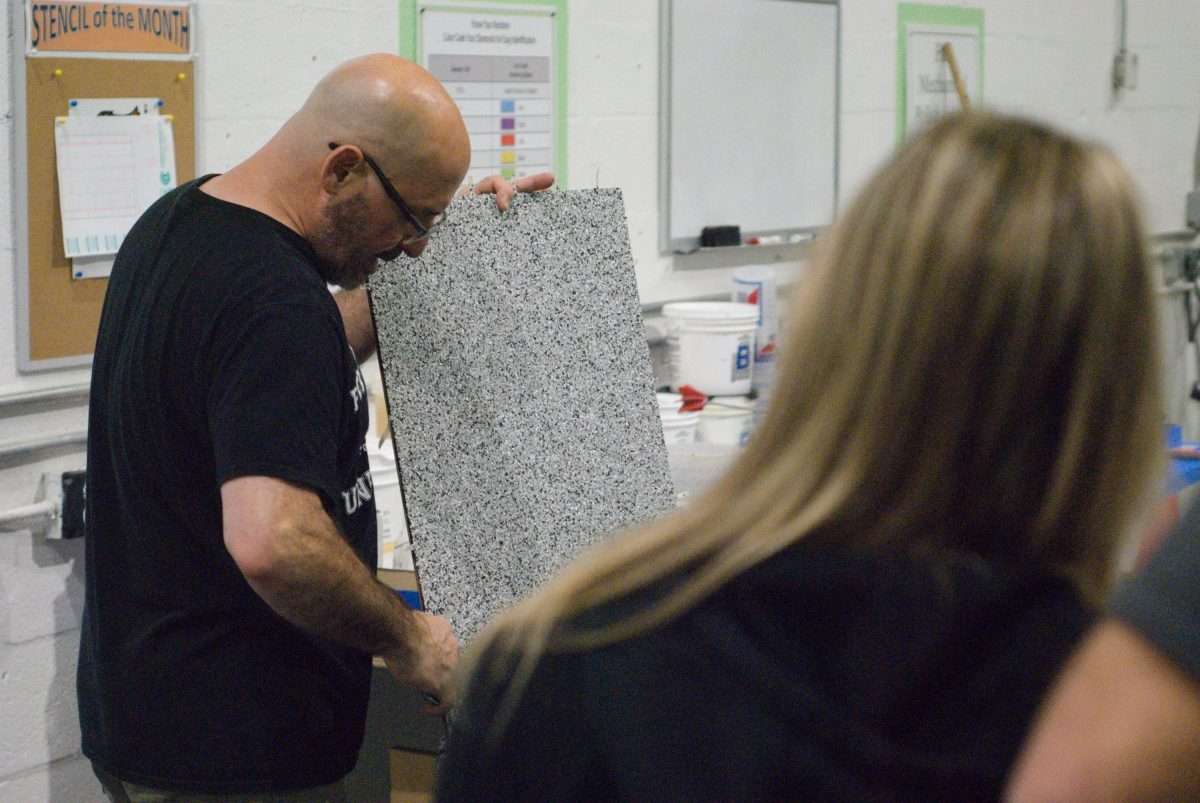 An image showing an epoxy professional teaching contractors about floor traction additives.