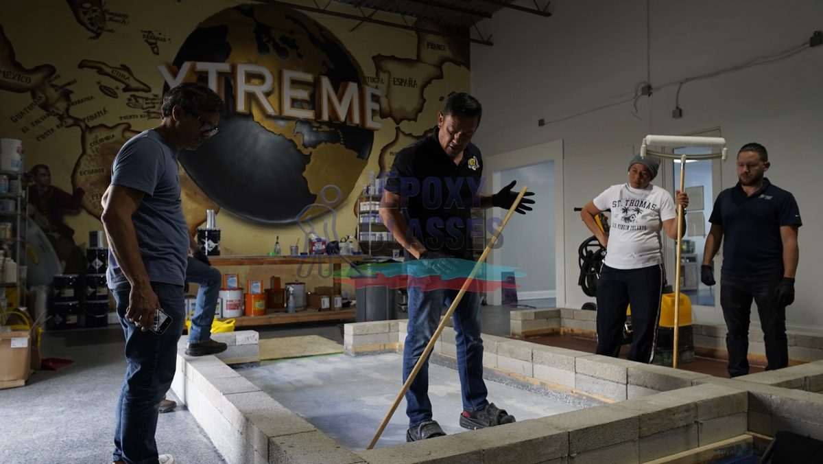 In person epoxy training course with student contractors in a warehouse setting.