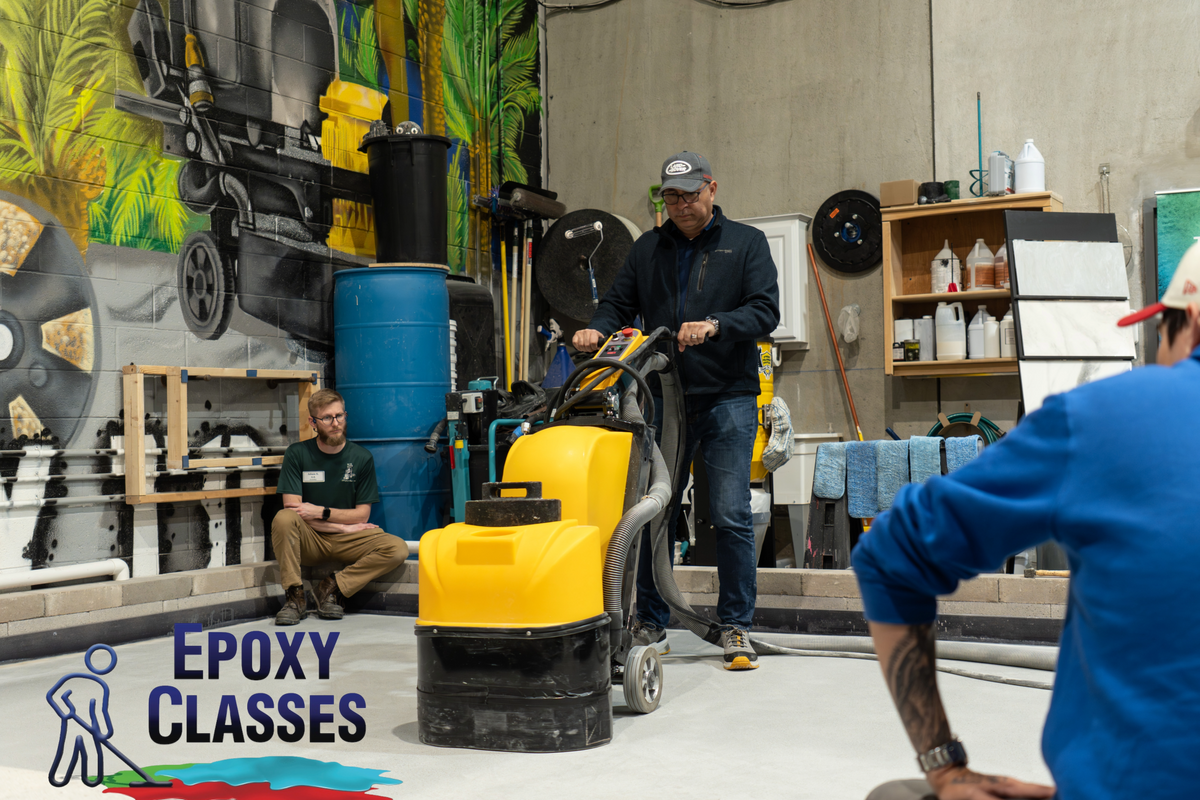 An epoxy resin contractor in epoxy training using a concrete floor grinder.