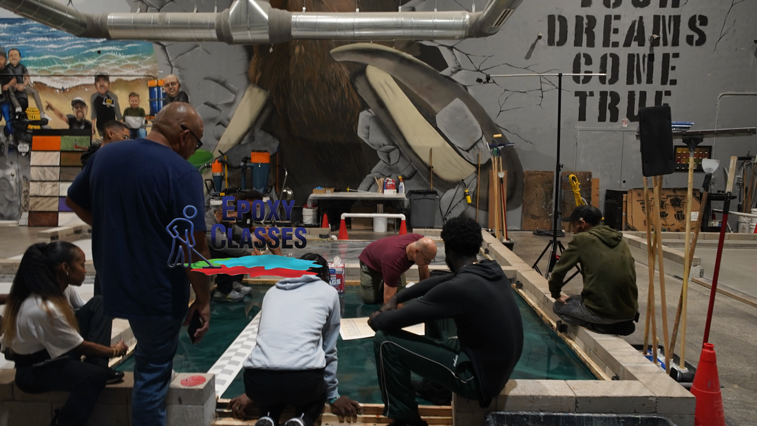 An epoxy resin training class in a warehouse setting installing a metallic blue resinous coating.